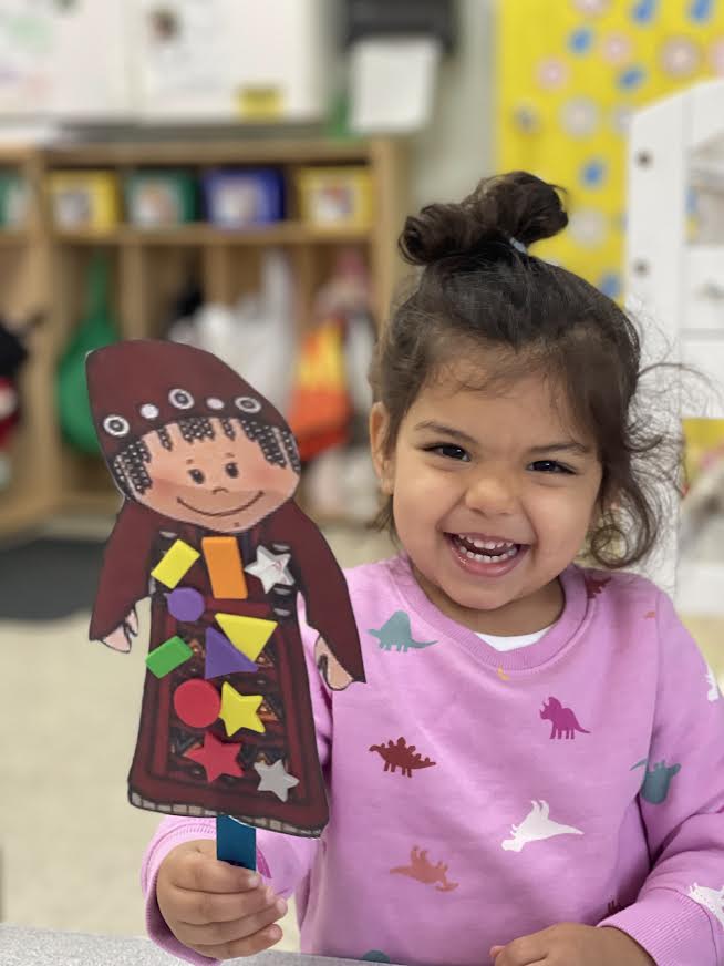 smiling kid holding a puppet